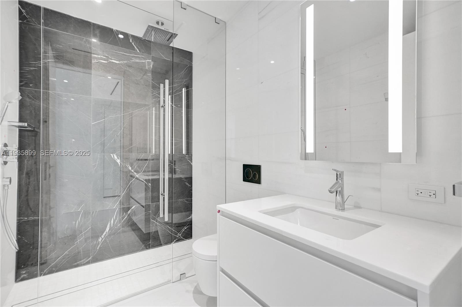 300 Biscayne Blvd Way, Unit 3605W Miami, FL 33131 - Photo 23 of 65 a bathroom with a sink and mirror with bathtub