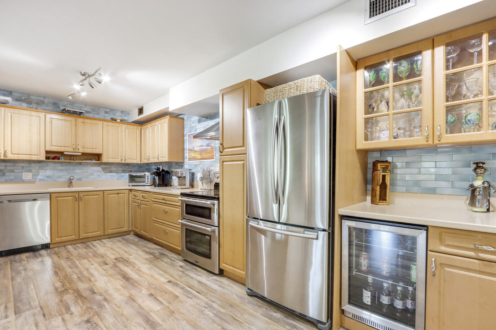 a kitchen with granite countertop stainless steel appliances a refrigerator and cabinets