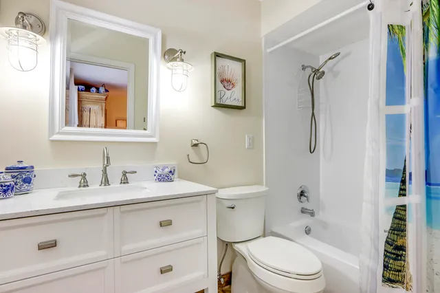 a bathroom with a sink toilet vanity and shower