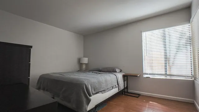 a bedroom with a bed and a flat tv screen on a dresser