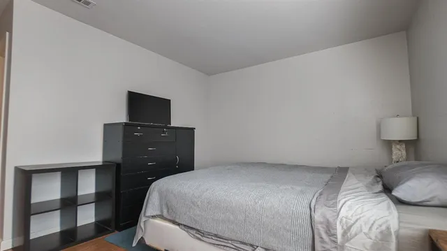 a bedroom with a bed and a television