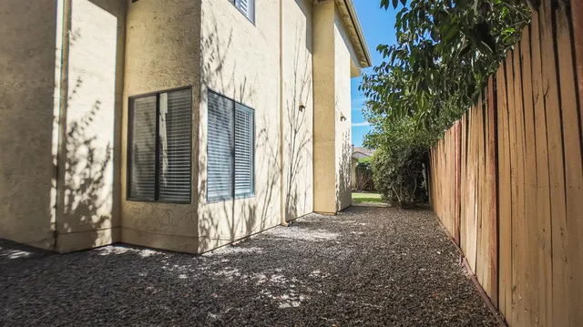 a balcony with table and chairs and potted plants