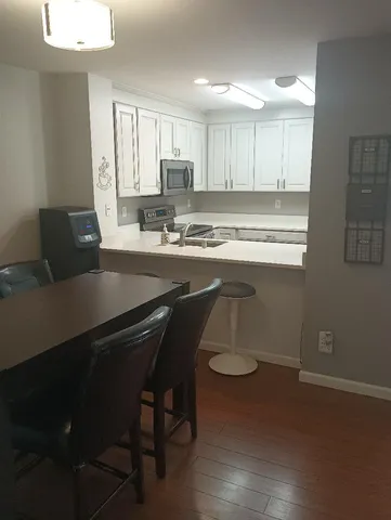 a kitchen with a table chairs sink and cabinets