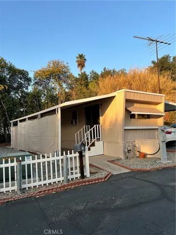 a view of a house with a small yard and wooden fence