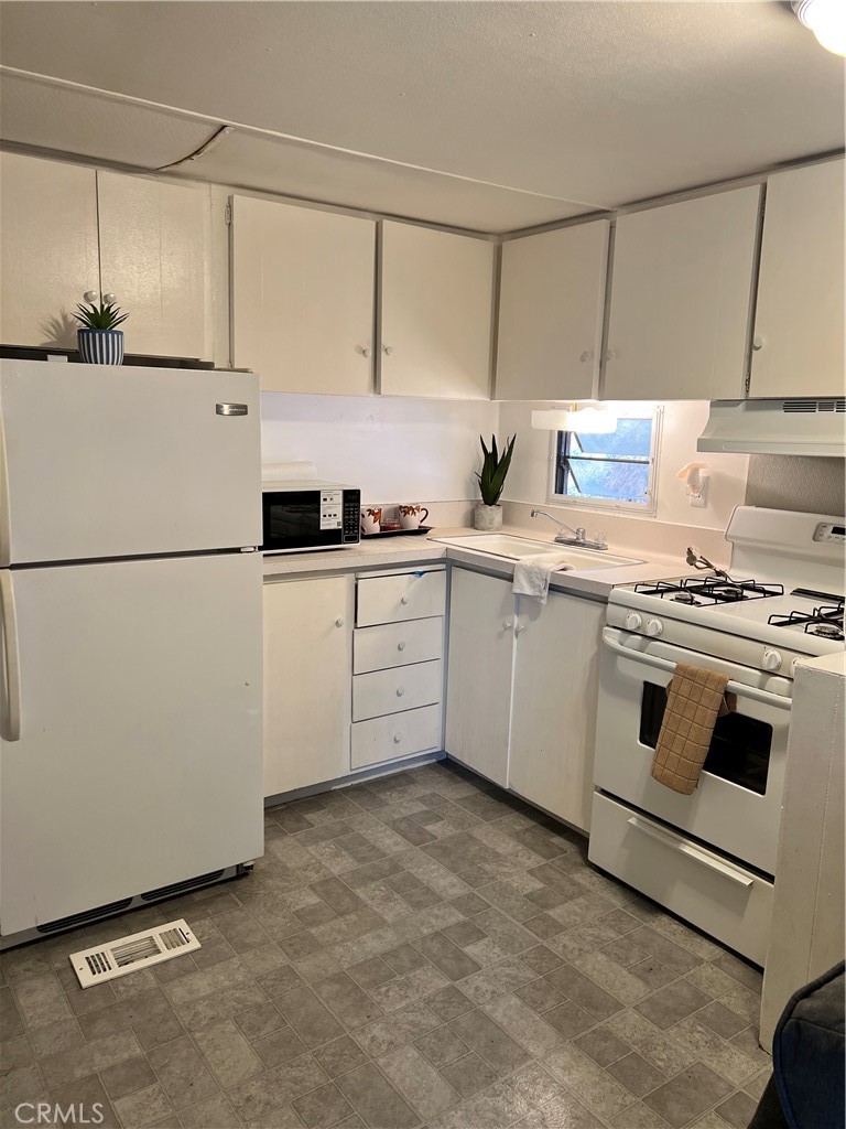 35080 Chandler Avenue, Unit 11 Calimesa, CA 92320 - Photo 7 of 20 a kitchen with stainless steel appliances a sink and a refrigerator