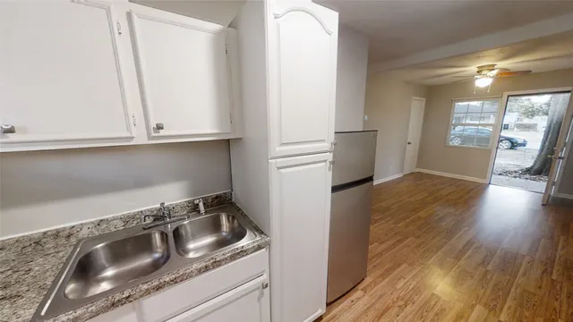 a kitchen with granite countertop a refrigerator and a sink