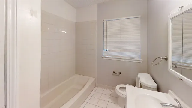 a bathroom with a sink and bathtub with toilet