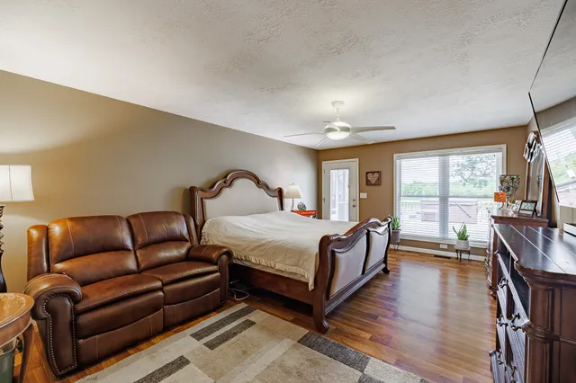 a bedroom with bed couch and window