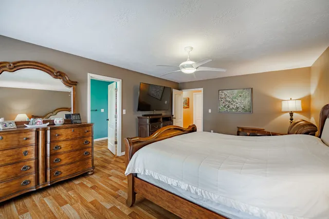 a bedroom with a bed and a dresser with mirror