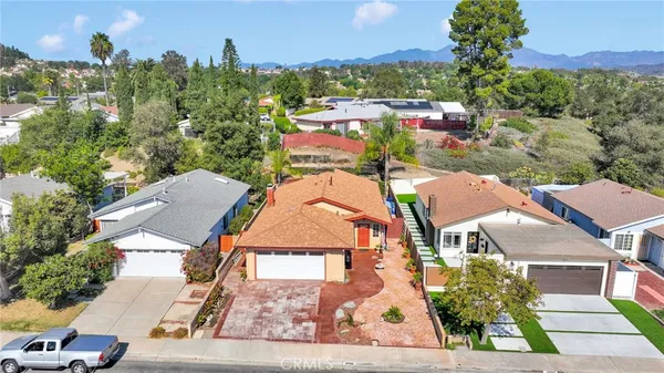 an aerial view of residential houses with outdoor space and trees