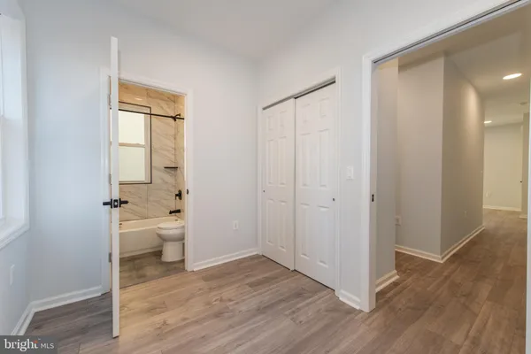 an empty room with wooden floor and a toilet