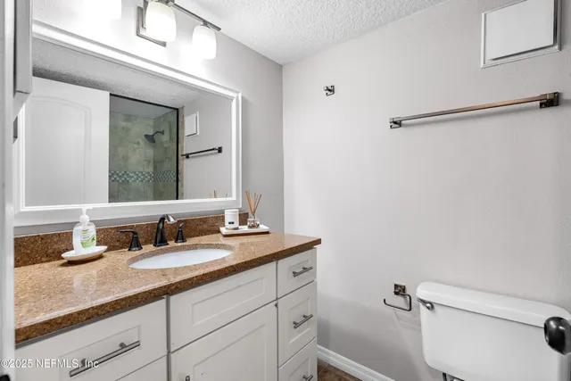 a bathroom with a granite countertop sink toilet and shower
