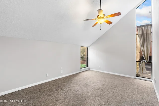 an empty room with closet and fan