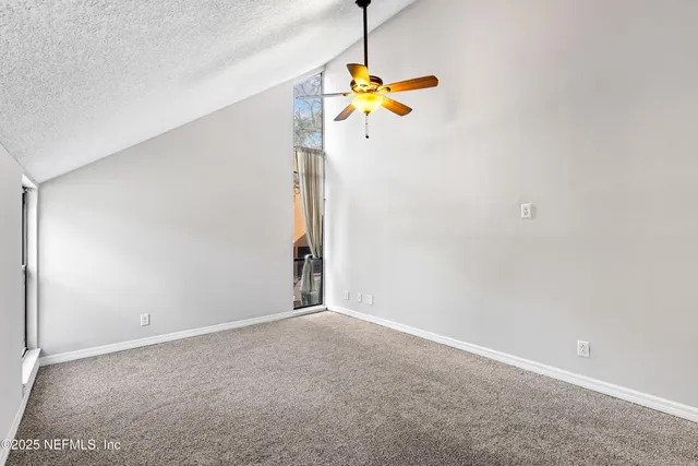 a view of a room with a ceiling fan and window