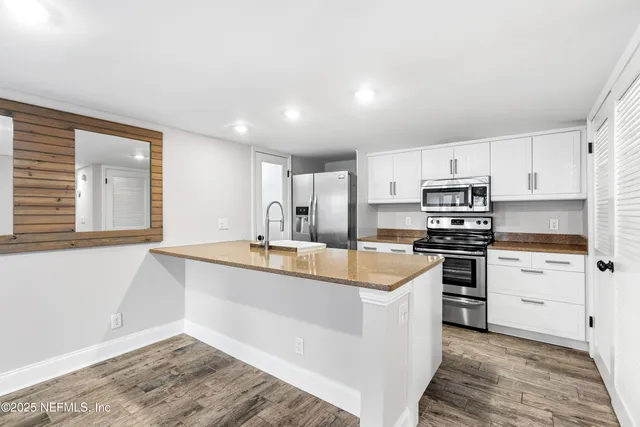 a kitchen with stainless steel appliances a sink stove and refrigerator