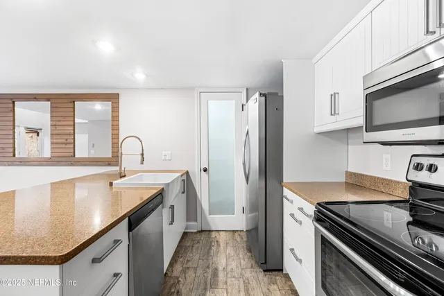 a kitchen with granite countertop cabinets stainless steel appliances and wooden floor