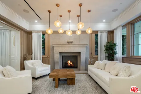 a living room with couch a fireplace and a chandelier