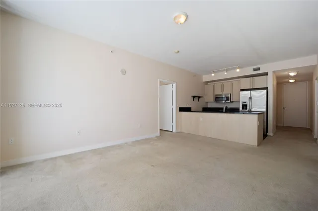 a view of a kitchen with a refrigerator and a sink