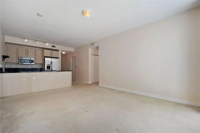 a kitchen with stainless steel appliances a refrigerator sink and microwave