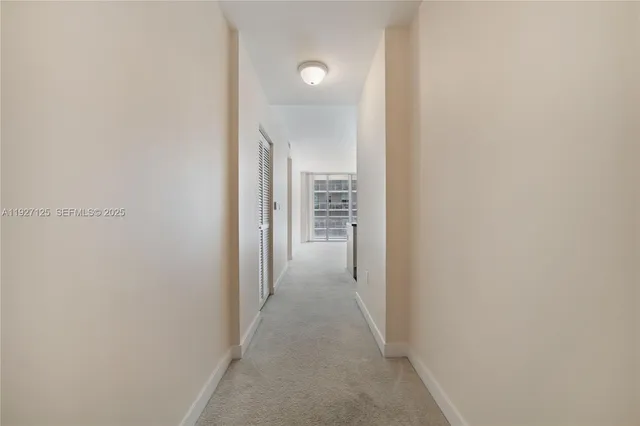 a view of a hallway with wooden cabinets