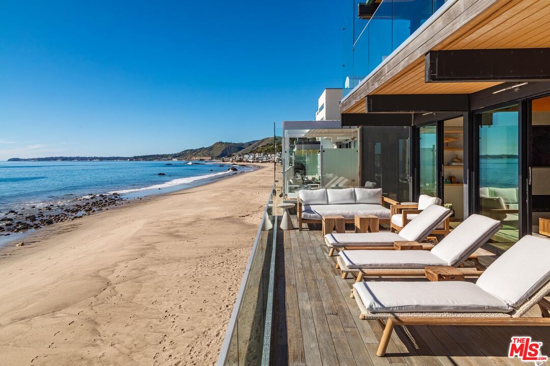 24548 Malibu Road Malibu, CA 90265 - Photo 13 of 28 a view of a patio with lawn chairs under an umbrella