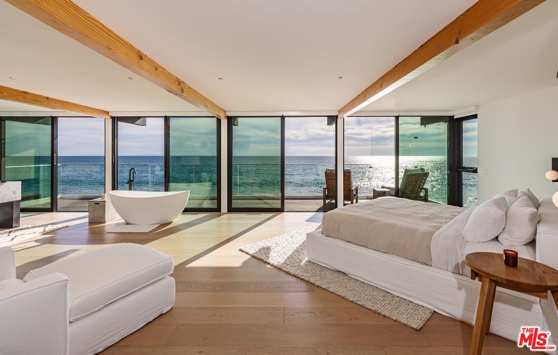 24548 Malibu Road Malibu, CA 90265 - Photo 15 of 28 a spacious bedroom with a large bed and a large window