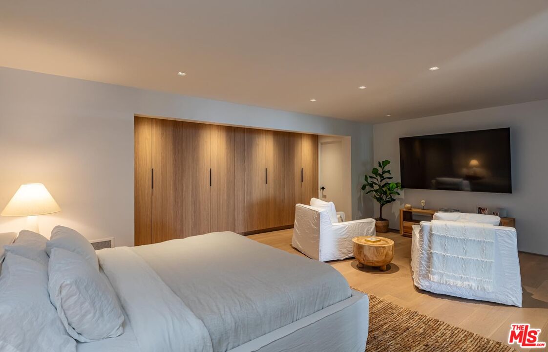 24548 Malibu Road Malibu, CA 90265 - Photo 22 of 28 a spacious bedroom with a bed and a flat screen tv