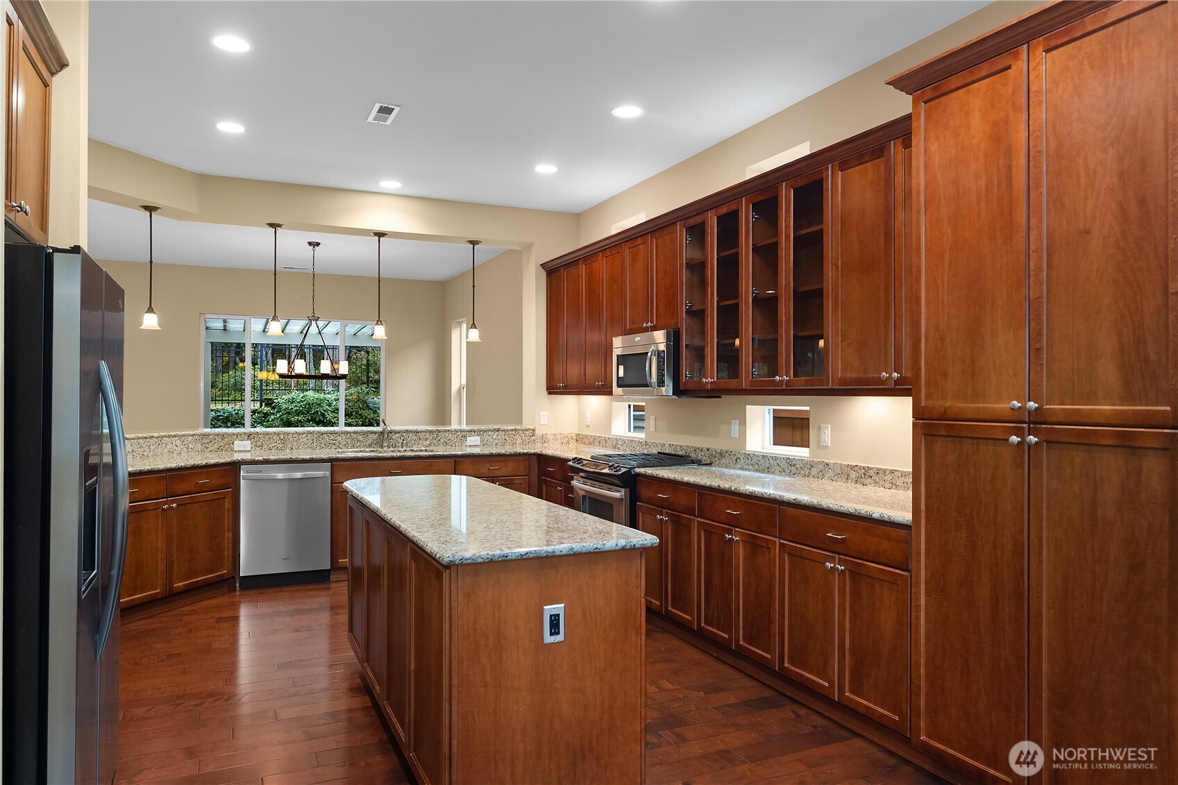 8265 Orcas Loop Northeast Lacey, WA 98516 - Photo 7 of 39 a kitchen with kitchen island granite countertop a sink stove and refrigerator
