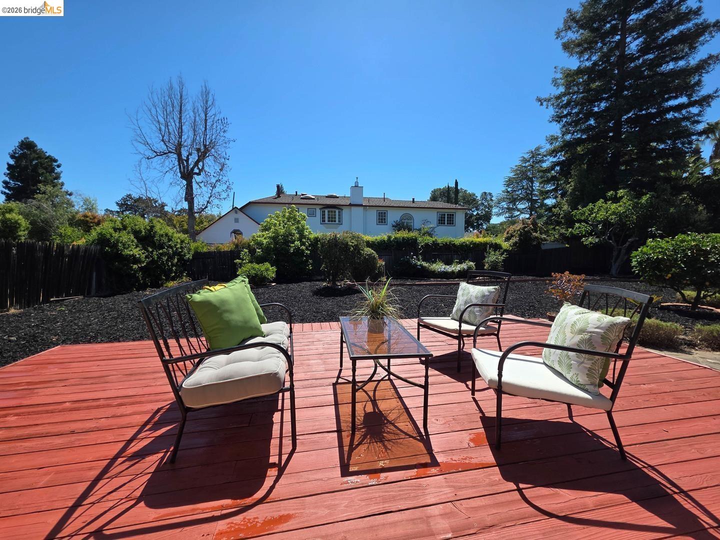 965 Springer Road Los Altos, CA 94024 - Photo 22 of 31 Expansive red-stained wood deck featuring surrounding landscaping with mature trees and dark ground cover