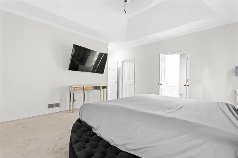 a spacious bedroom with a bed and a flat screen tv