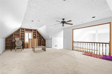 a view of an empty room with furniture and a window