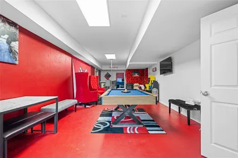 a living room with furniture pool table and chairs