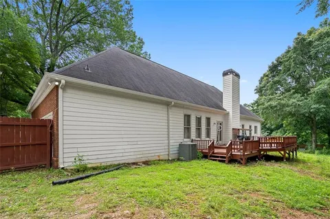 a backyard of a house with barbeque oven and fence