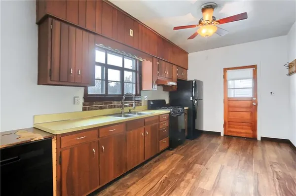 a kitchen with stainless steel appliances granite countertop a sink a stove cabinets and wooden floor