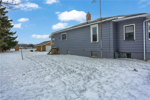 a backyard of a house with barbeque oven table and chairs