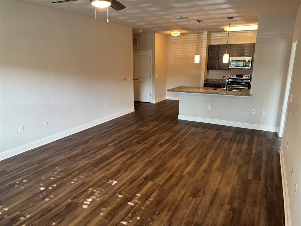 2460 Ann Rou Road, Unit 606 Tavares, FL 32778 - Photo 6 of 18 a view of a room with wooden floor and a chandelier