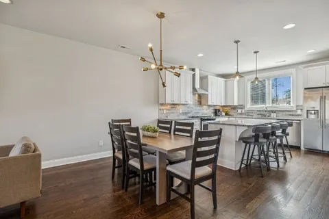 a kitchen with stainless steel appliances granite countertop a sink a stove a refrigerator cabinets and wooden floor