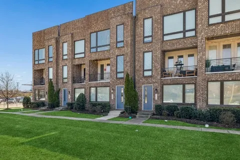 front view of a brick house with a yard