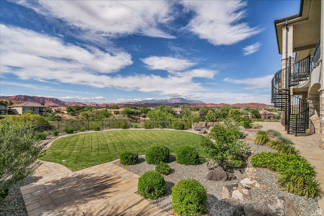 2608 Canyon Ridge Drive St. George, UT 84770 - Photo 85 of 86 Expansive backyard featuring a manicured lawn, paver patio, and low-maintenance landscaping