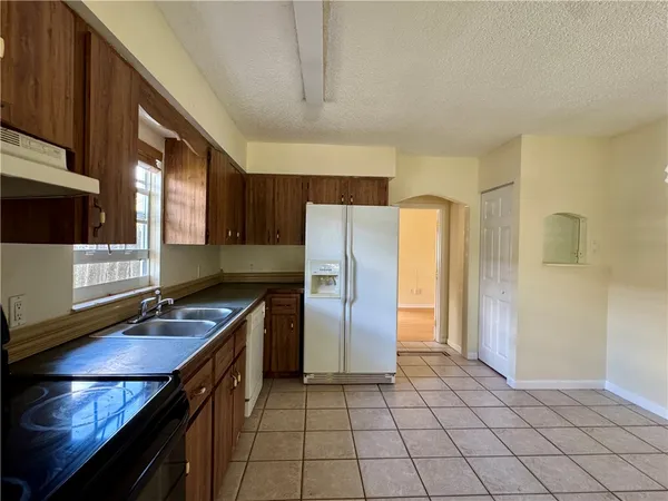 a kitchen with a refrigerator a sink and cabinets