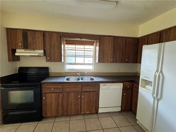 a kitchen with a stove sink and refrigerator