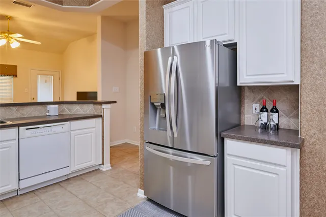a kitchen with stainless steel appliances granite countertop a refrigerator and a sink