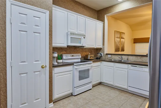 a kitchen with white cabinets and white appliances