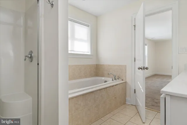 a bathroom with a tub a sink and a window