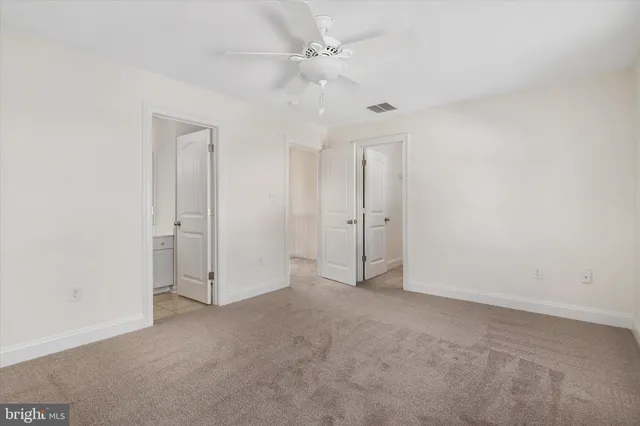 an empty room with fan and entrance