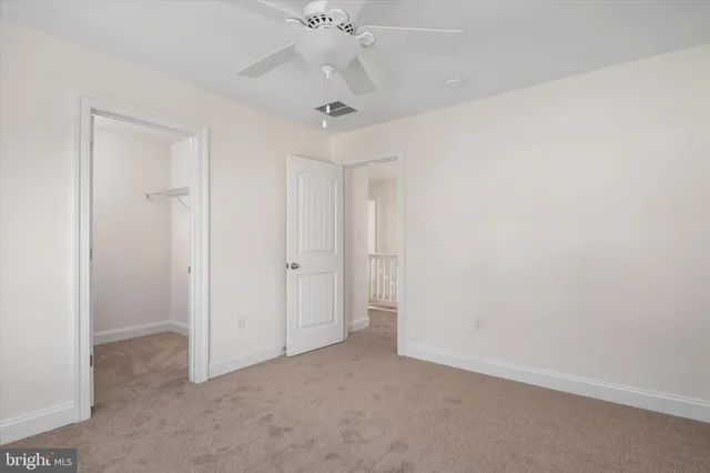 an empty room with a ceiling fan and a window