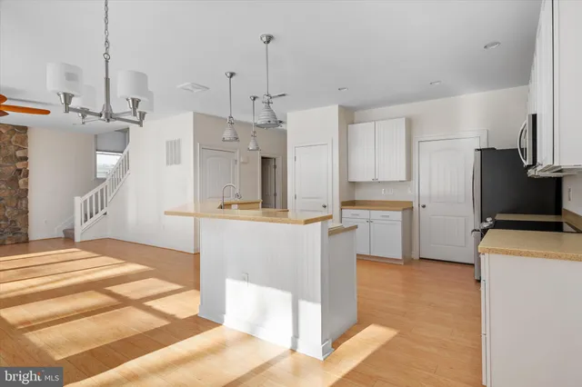 a large kitchen with cabinets and a refrigerator