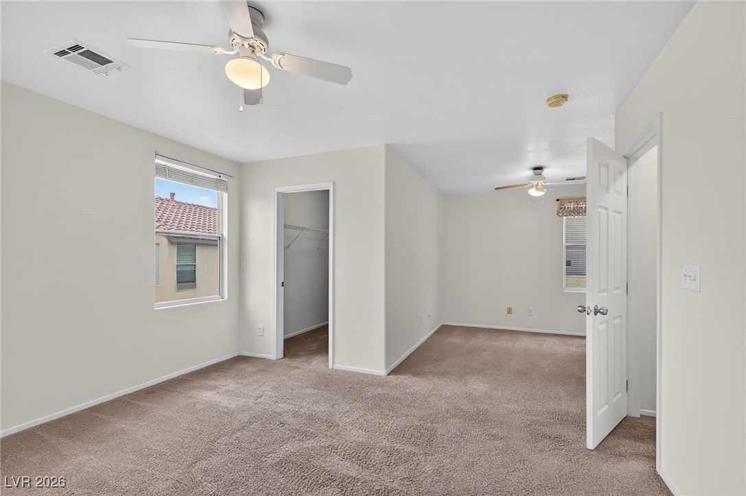 8038 Kings Ransom Street Las Vegas, NV 89139 - Photo 15 of 38 Unfurnished bedroom with a spacious closet, ceiling fan, and light colored carpet