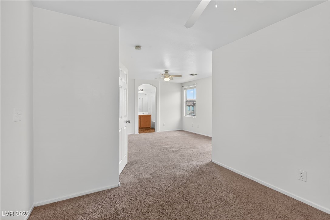 8038 Kings Ransom Street Las Vegas, NV 89139 - Photo 27 of 38 Carpeted spare room with arched walkways and a ceiling fan