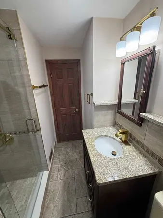 a bathroom with a granite countertop sink and mirror